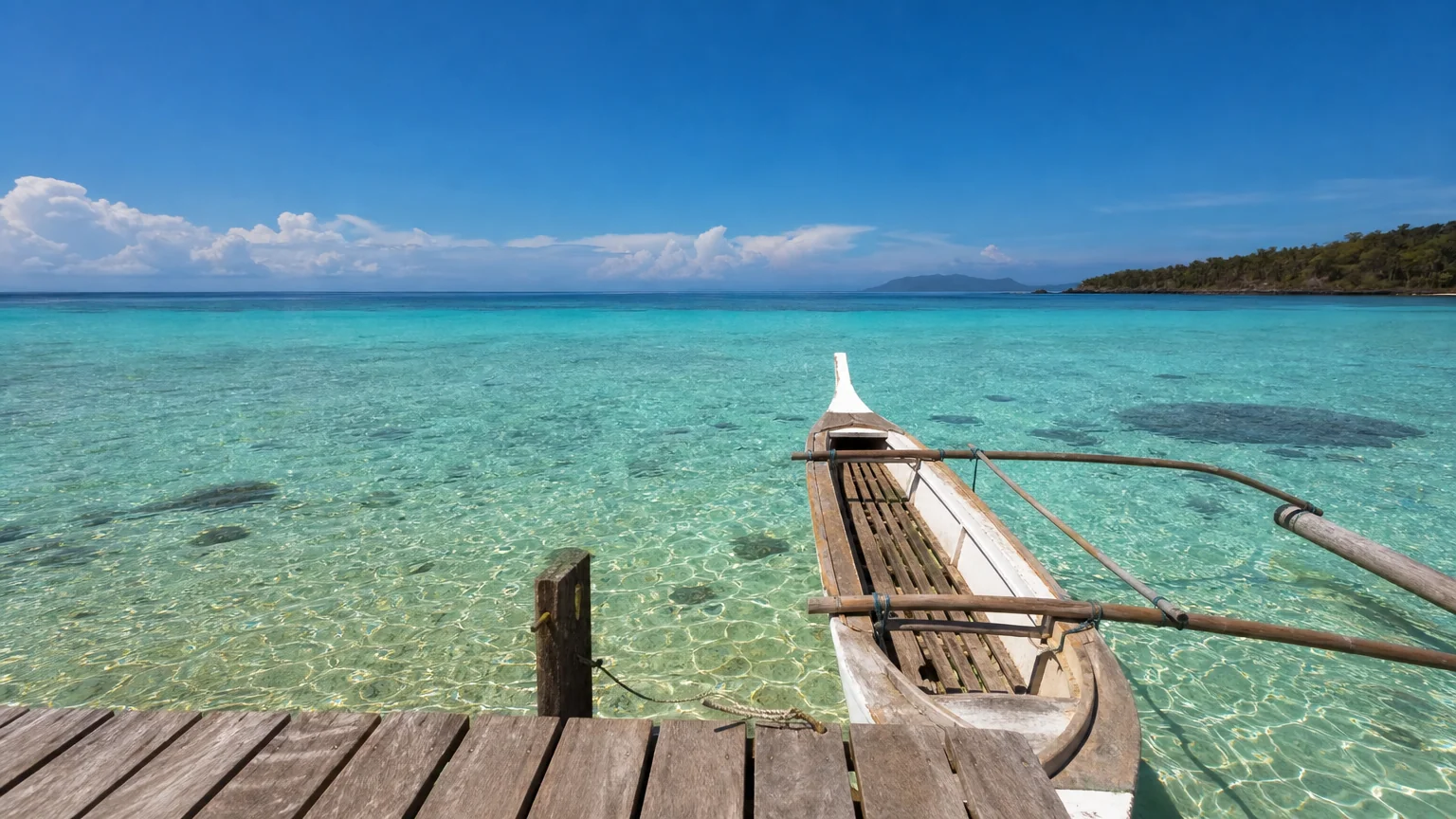 Mer turquoise et ponton en bois au bord d’une plage